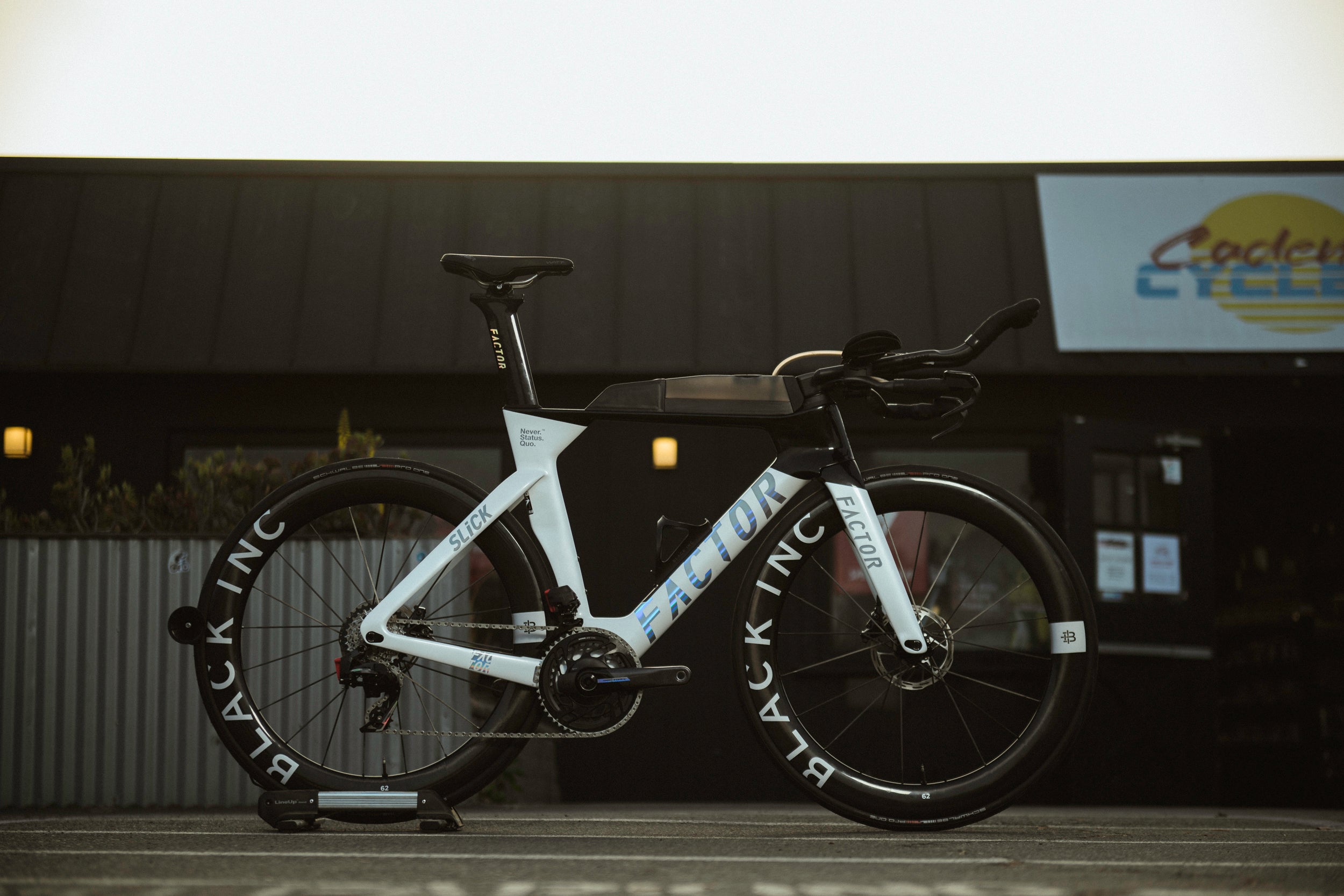 Black and white bicycle Factor triathlon bike on a stand with a blurred background