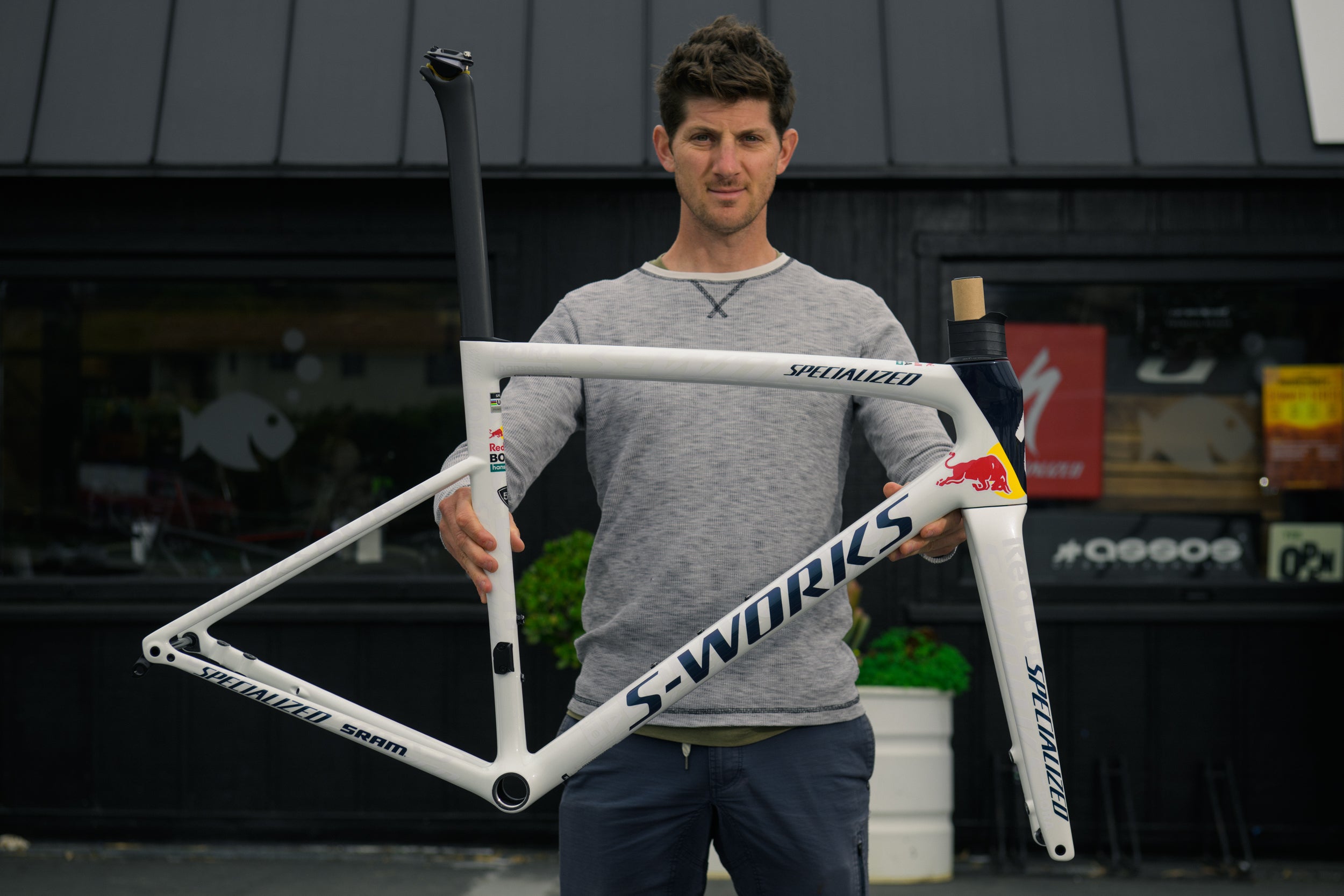 Man holding a Specialized Custom S-Works bicycle frame in an outdoor setting